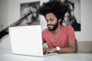 Man Researching Cloud-Based Solutions and Phone Systems on His Laptop