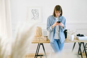 Woman Using Her Mobile Device to Make a Phone Call From Her Home Office
