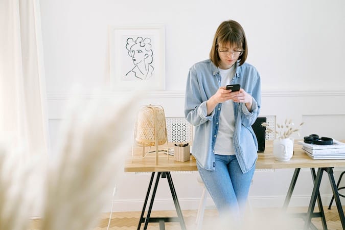 Woman Using Her Mobile Device to Make a Phone Call From Her Home Office